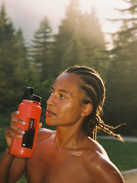 Runner drinking from an activated charcoal bottle